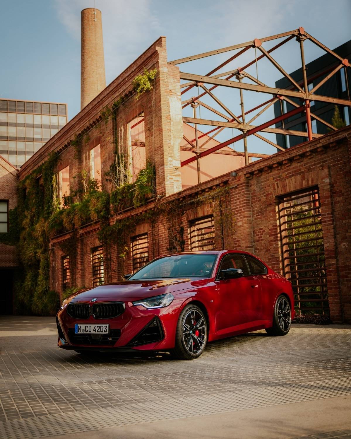 红色宝马M240i xDrive双门轿跑停在砖墙厂房前的官方照片